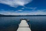Experience serene lakefront living with this stunning property featuring a private dock extending into crystal-clear waters.