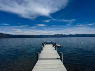 Experience serene lakefront living with this stunning property featuring a private dock extending into crystal-clear waters.