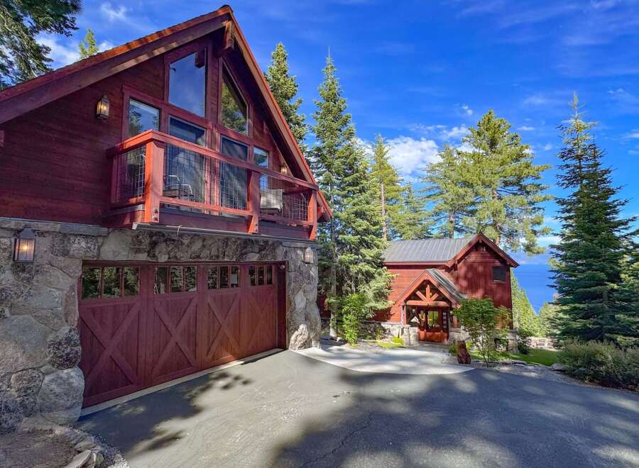 Experience luxury mountain living in this stunning timber-frame home, featuring a spacious garage and a charming covered entryway.