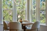 Enjoy your morning coffee in this charming breakfast nook, bathed in natural light from large, grid-pane windows.