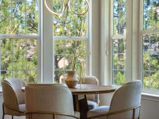 Enjoy your morning coffee in this charming breakfast nook, bathed in natural light from large, grid-pane windows.
