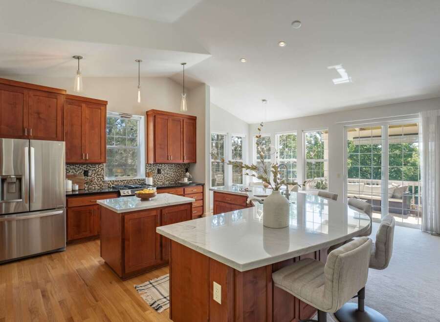 This spacious kitchen boasts rich cherry wood cabinetry and gleaming marble countertops, perfect for the home chef.