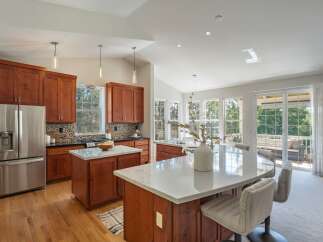 This spacious kitchen boasts rich cherry wood cabinetry and gleaming marble countertops, perfect for the home chef.