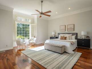Experience luxurious comfort in this stunning bedroom, featuring a spacious king-size bed adorned with plush pillows and a cozy throw.