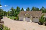 This property boasts a spacious three-car garage with charming yellow siding and white trim, perfect for vehicle storage and hobbies.