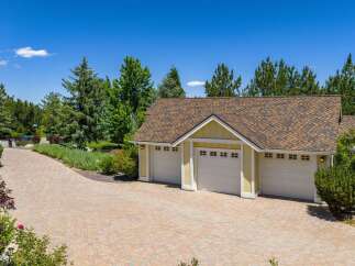 This property boasts a spacious three-car garage with charming yellow siding and white trim, perfect for vehicle storage and hobbies.