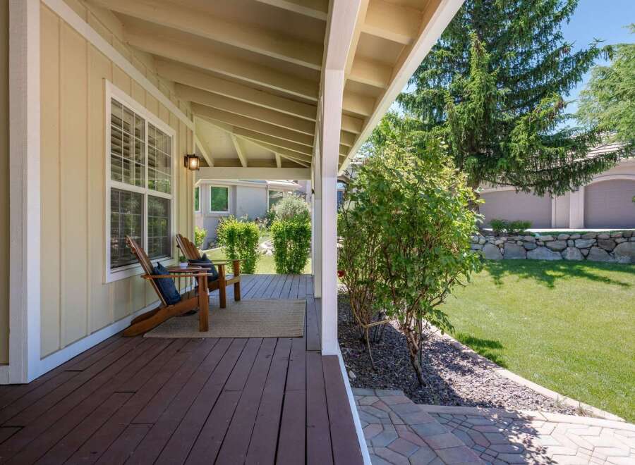 Enjoy relaxing evenings on this charming covered porch, complete with two Adirondack chairs and a cozy rug.