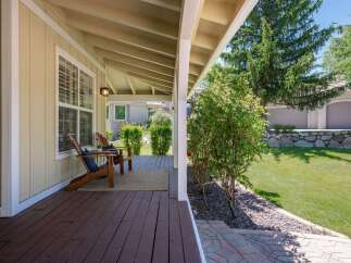 Enjoy relaxing evenings on this charming covered porch, complete with two Adirondack chairs and a cozy rug.