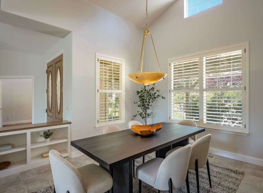 This elegant dining room features a dark wood dining table with upholstered chairs, perfect for hosting gatherings.