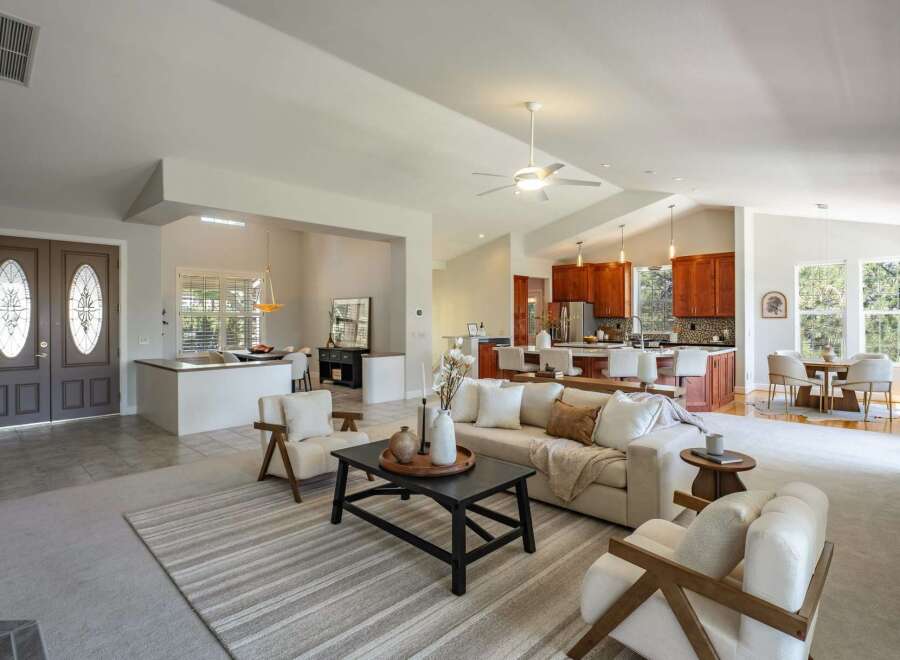 Step into this beautifully appointed open-concept living space, featuring a modern kitchen with rich wood cabinetry and a spacious island perfect for entertaining.