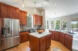 Experience luxury living in this stunning kitchen featuring rich cherry wood cabinetry and sleek granite countertops.