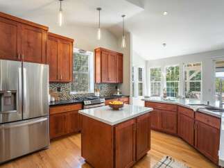 Experience luxury living in this stunning kitchen featuring rich cherry wood cabinetry and sleek granite countertops.
