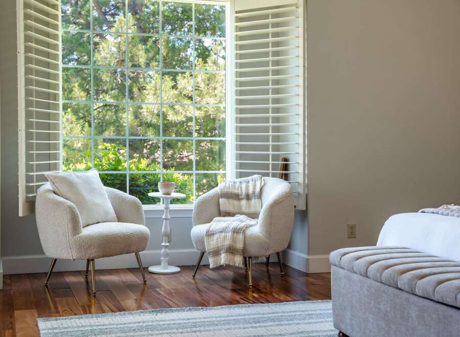 Relax in comfort with these two plush armchairs, perfect for enjoying the natural light streaming through the large window.