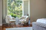 Relax in comfort with these two plush armchairs, perfect for enjoying the natural light streaming through the large window.