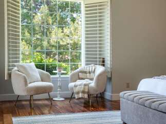 Relax in comfort with these two plush armchairs, perfect for enjoying the natural light streaming through the large window.