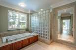 Indulge in luxury with this stunning bathroom featuring a deep soaking tub and a modern glass block shower enclosure.