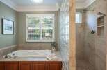 Indulge in luxury with this stunning bathroom featuring a deep soaking tub and a spacious walk-in shower with dual showerheads.