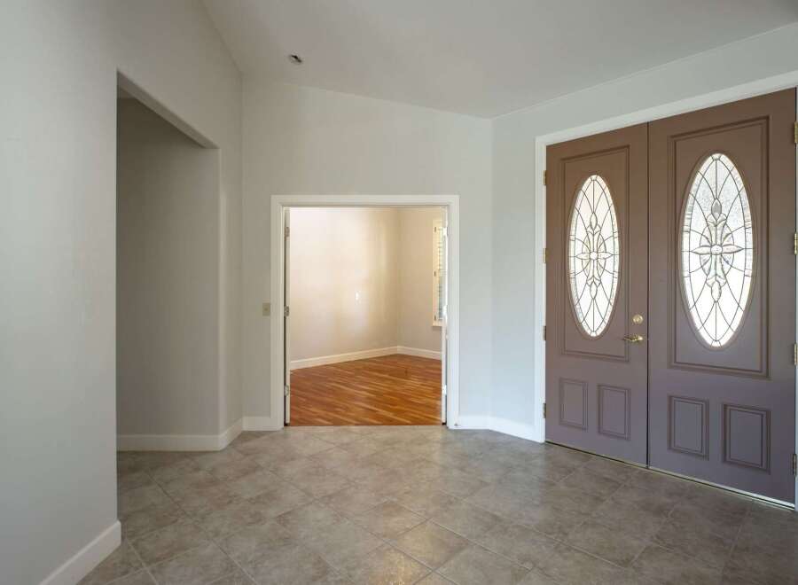 Step into a welcoming entryway featuring elegant double doors with decorative glass panels.