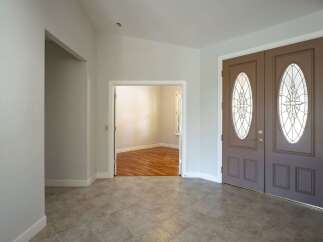 Step into a welcoming entryway featuring elegant double doors with decorative glass panels.