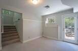 Discover this inviting space featuring a carpeted staircase leading to an upper level with a charming window view.