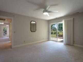 Step into this spacious bedroom featuring plush carpeting and a modern ceiling fan for ultimate comfort.