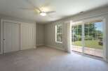 Step into this spacious bedroom featuring a modern ceiling fan and ample closet space behind elegant double doors.
