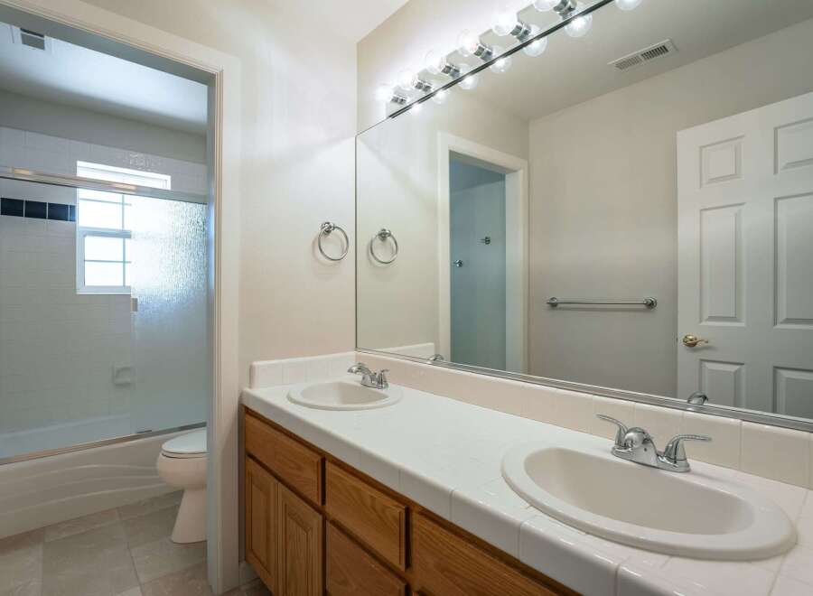This spacious bathroom features a double vanity with ample counter space and two sinks, perfect for busy mornings.