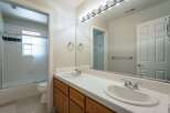 This spacious bathroom features a double vanity with ample counter space and two sinks, perfect for busy mornings.