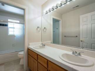 This spacious bathroom features a double vanity with ample counter space and two sinks, perfect for busy mornings.