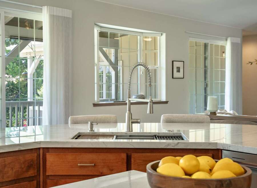 Experience luxury in this stunning kitchen featuring a sleek marble countertop and a modern faucet.
