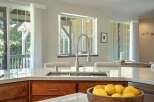 Experience luxury in this stunning kitchen featuring a sleek marble countertop and a modern faucet.