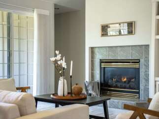 Cozy living room featuring a gas fireplace with a marble tile surround, perfect for chilly evenings.