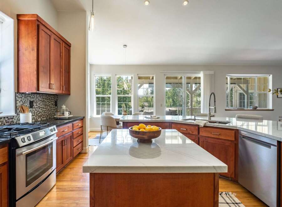 Experience the heart of this home with a spacious kitchen featuring rich cherry wood cabinetry and gleaming marble countertops.
