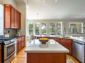 Experience the heart of this home with a spacious kitchen featuring rich cherry wood cabinetry and gleaming marble countertops.