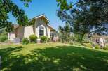 Discover this charming home featuring a spacious, manicured lawn perfect for outdoor activities and a welcoming porch with white railings.