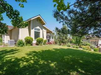 Discover this charming home featuring a spacious, manicured lawn perfect for outdoor activities and a welcoming porch with white railings.