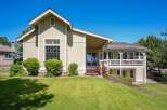 This charming home features a light beige exterior with white trim and a durable metal roof.