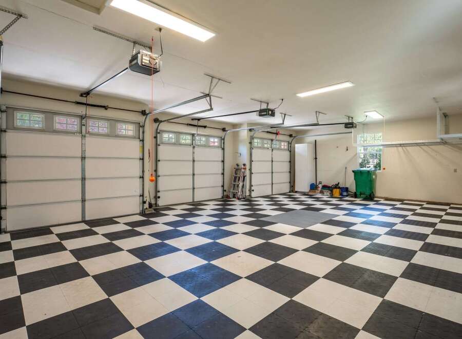This spacious garage features a striking black and white checkered floor, offering a clean and modern aesthetic.