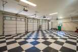 This spacious garage features a striking black and white checkered floor, offering a clean and modern aesthetic.