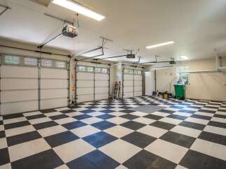This spacious garage features a striking black and white checkered floor, offering a clean and modern aesthetic.