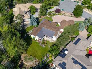 Discover this stunning aerial view of a sprawling estate, showcasing a magnificent home with a complex roofline and expansive grounds.