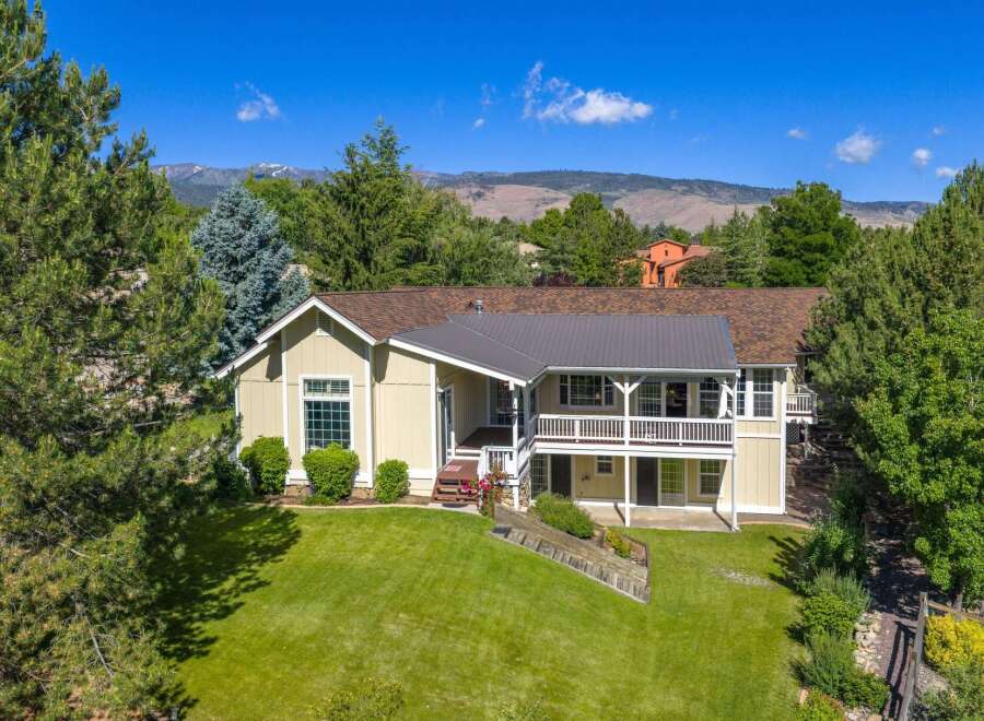 Nestled amidst mature trees and offering stunning mountain views, this charming home boasts a spacious multi-level deck perfect for entertaining or enjoying the serene surroundings.