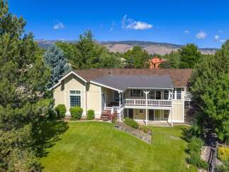 Nestled amidst mature trees and offering stunning mountain views, this charming home boasts a spacious multi-level deck perfect for entertaining or enjoying the serene surroundings.