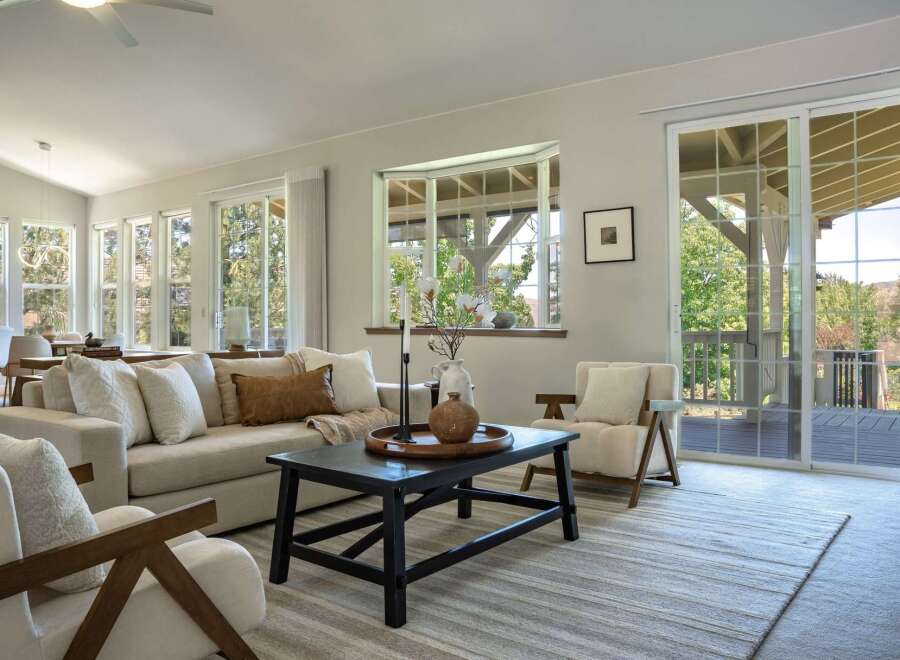 Experience seamless indoor-outdoor living in this beautifully appointed living room, featuring a spacious sectional sofa and comfortable armchairs perfect for relaxation.
