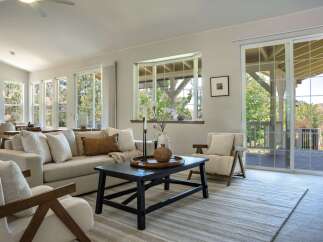 Experience seamless indoor-outdoor living in this beautifully appointed living room, featuring a spacious sectional sofa and comfortable armchairs perfect for relaxation.