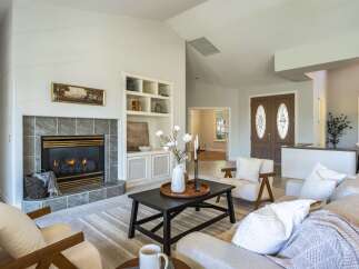 Step into this inviting living room, centered around a cozy fireplace with elegant tile surround and built-in shelving.