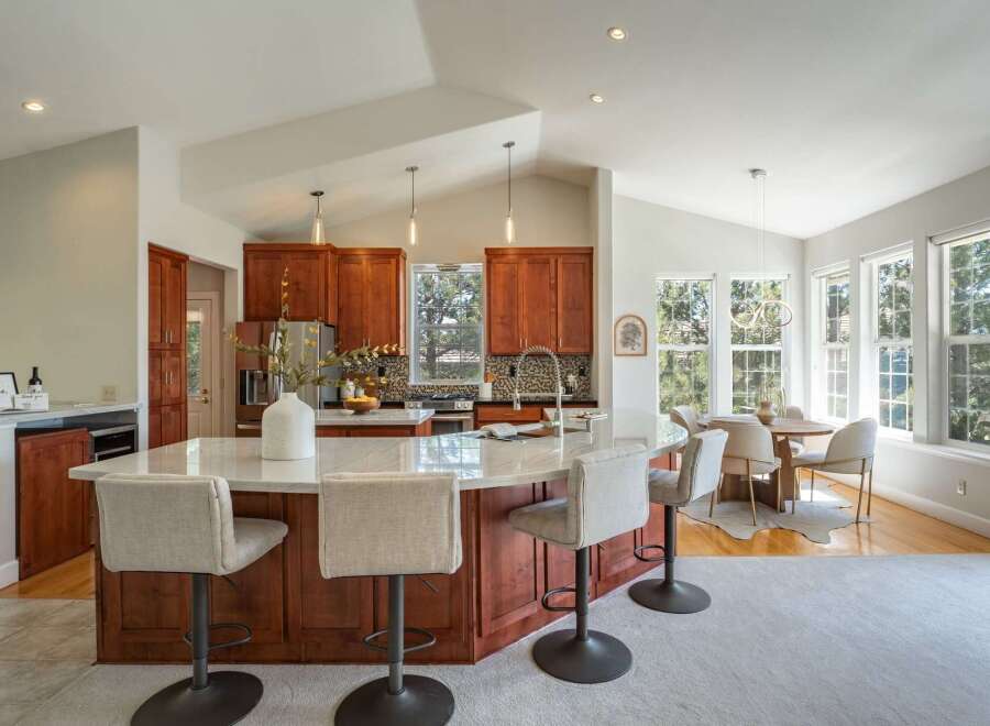 Experience the heart of this home with a spacious kitchen island featuring a marble countertop and comfortable bar seating, perfect for casual dining and entertaining.