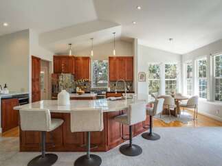 Experience the heart of this home with a spacious kitchen island featuring a marble countertop and comfortable bar seating, perfect for casual dining and entertaining.
