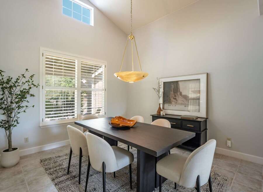 This dining room features a large, dark wood dining table with six upholstered chairs, perfect for family gatherings.