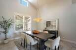This dining room features a large, dark wood dining table with six upholstered chairs, perfect for family gatherings.